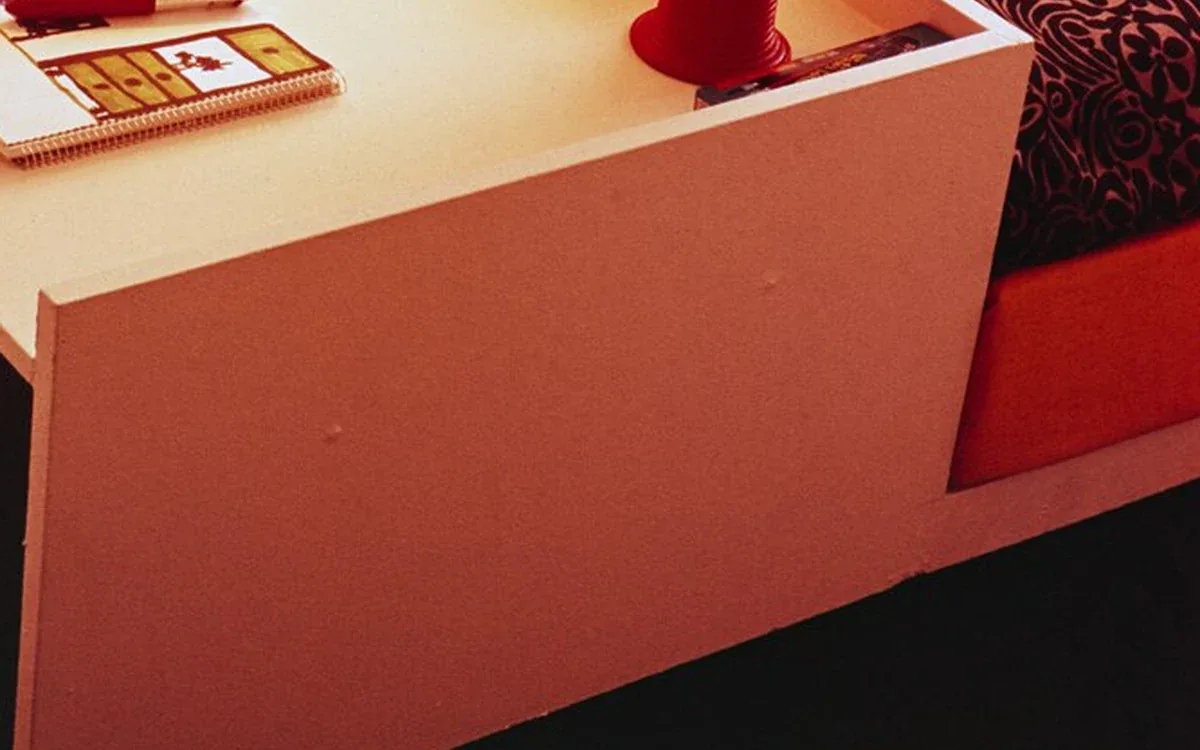 A pale storage drawer holds papers, small game pieces and a red container