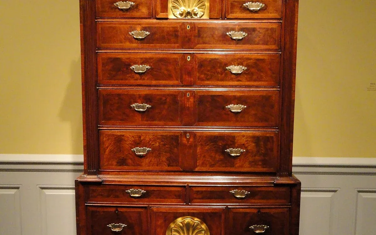 Warm wooden drawer fronts with decorative fittings and small pulls fill a chest