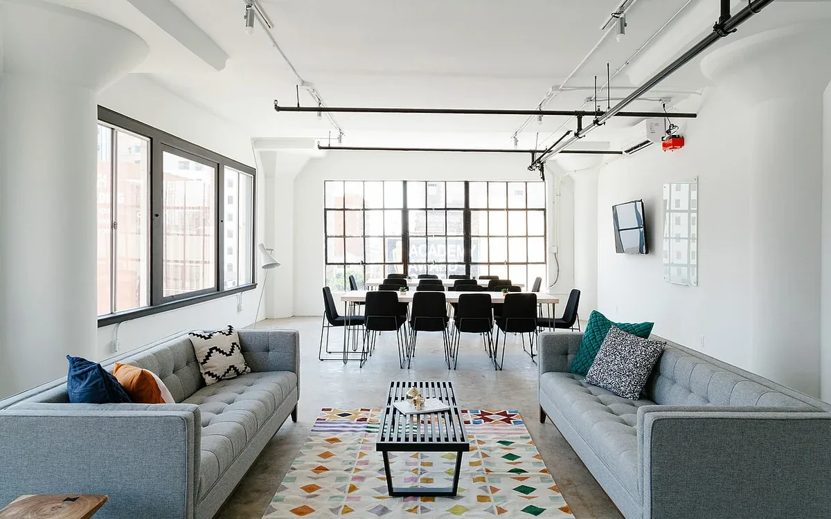 Two pale sofas face one another across a low table with a dining area beyond