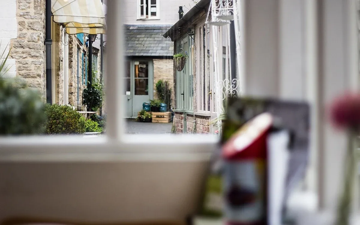 A window looks out toward nearby buildings above a softly blurred household surface